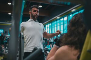 Instruktör välkomnar en medlem i ett gym med träningsutrustning