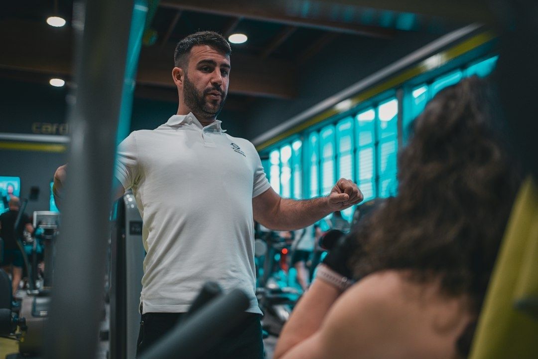 Instruktör välkomnar en medlem i ett gym med träningsutrustning